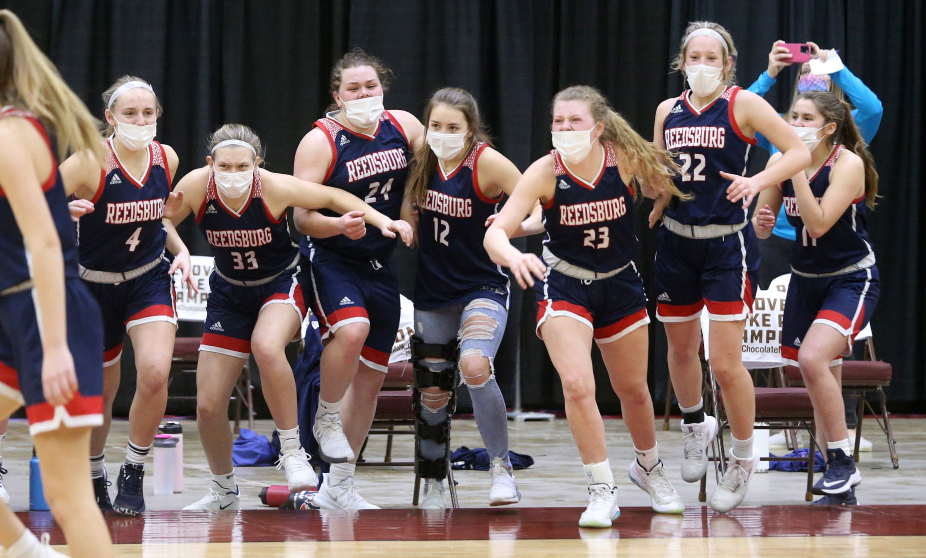WIAA state girls basketball photo: Reedsburg players storm the court after beating New Berlin Eisenhower